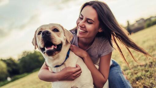 Woman smiling and hugging her dog
